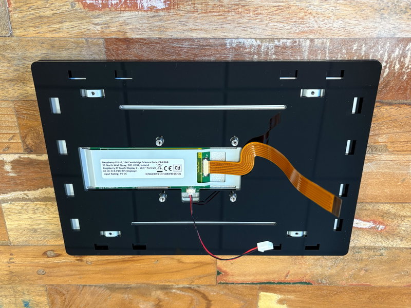 Third acrylic piece fitted over the back of the display with cables threaded through