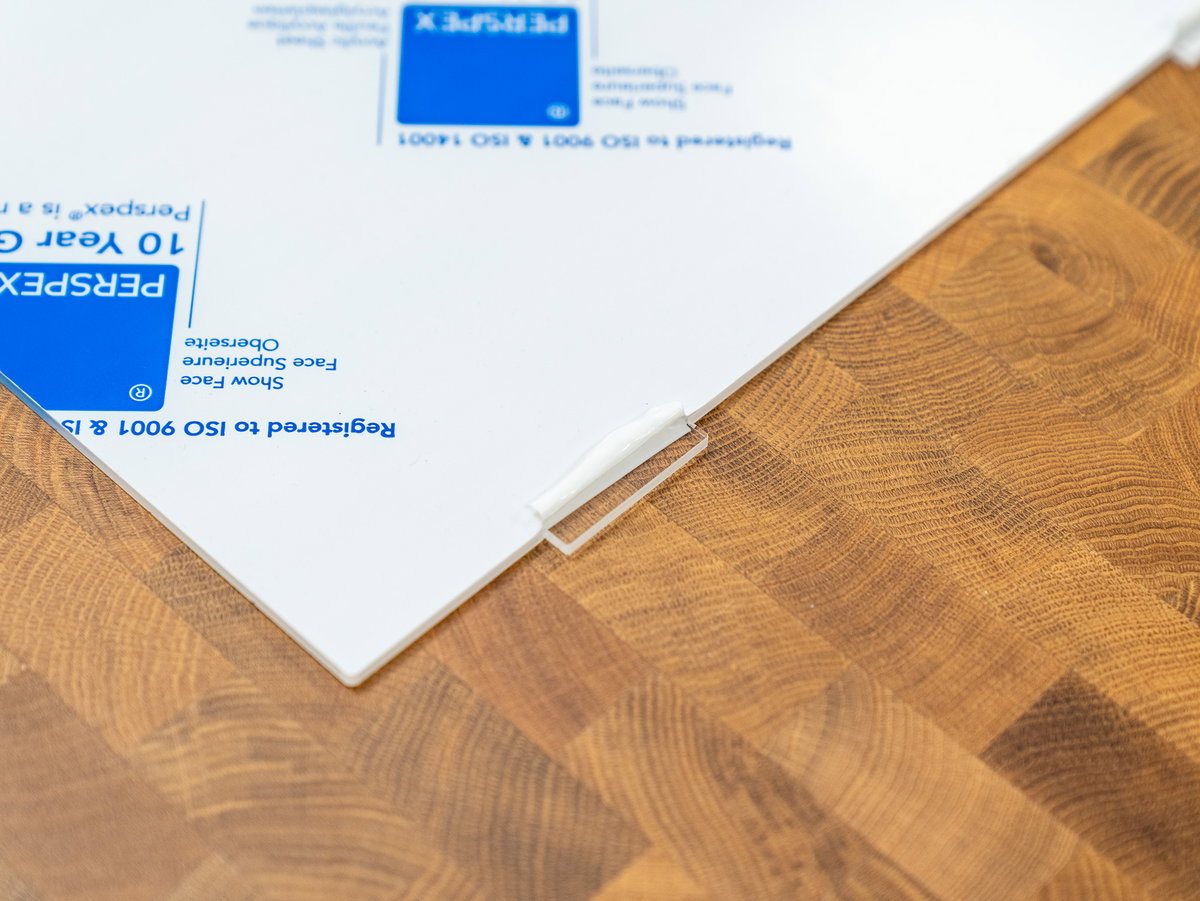 Peeling the protective backing off the tabs of the acrylic screen panel