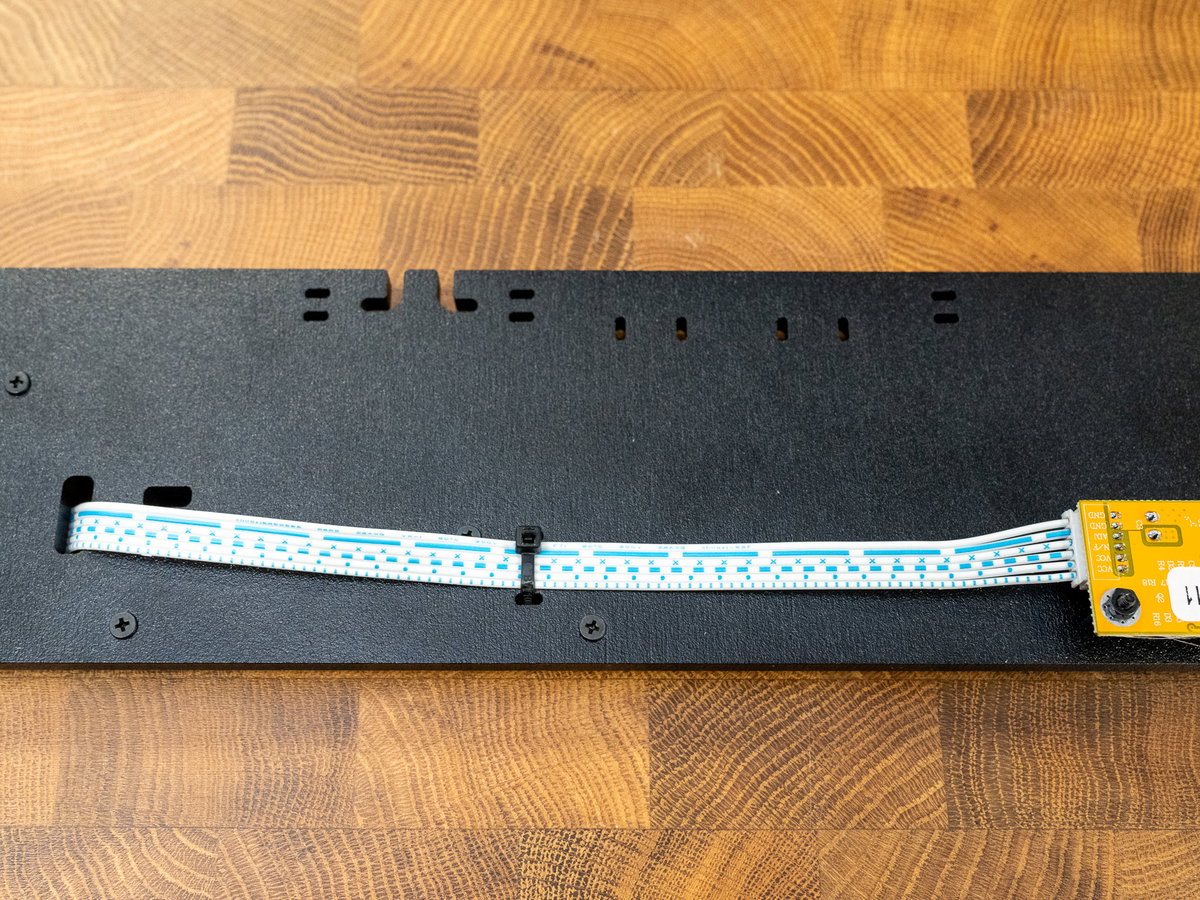 White display cable routed through the slot in panel K