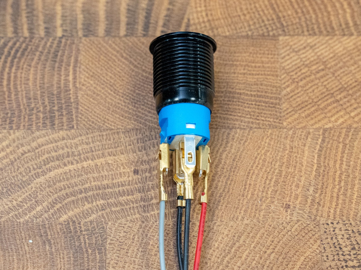 Red, grey, and black wires connected to the power button contacts
