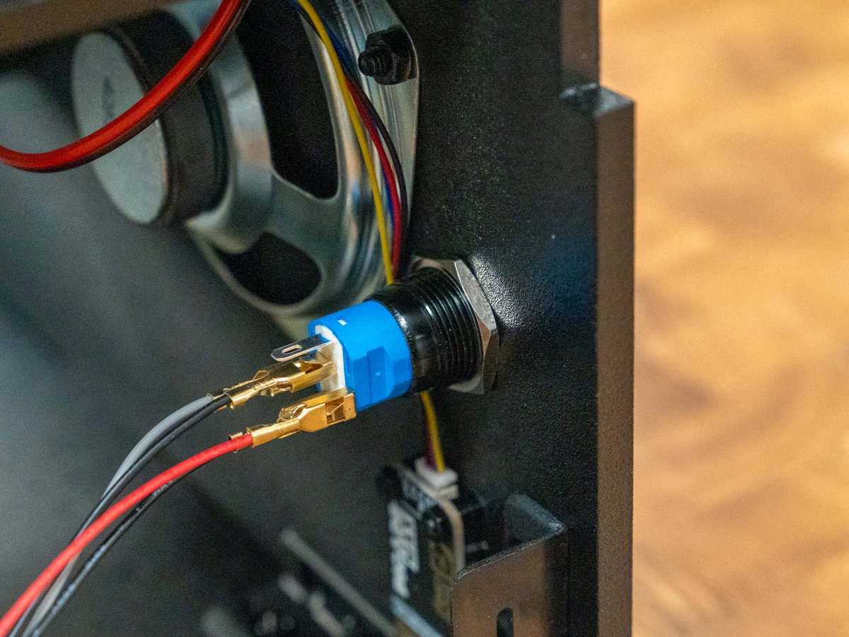 Metal hex ring securing the power button inside panel E