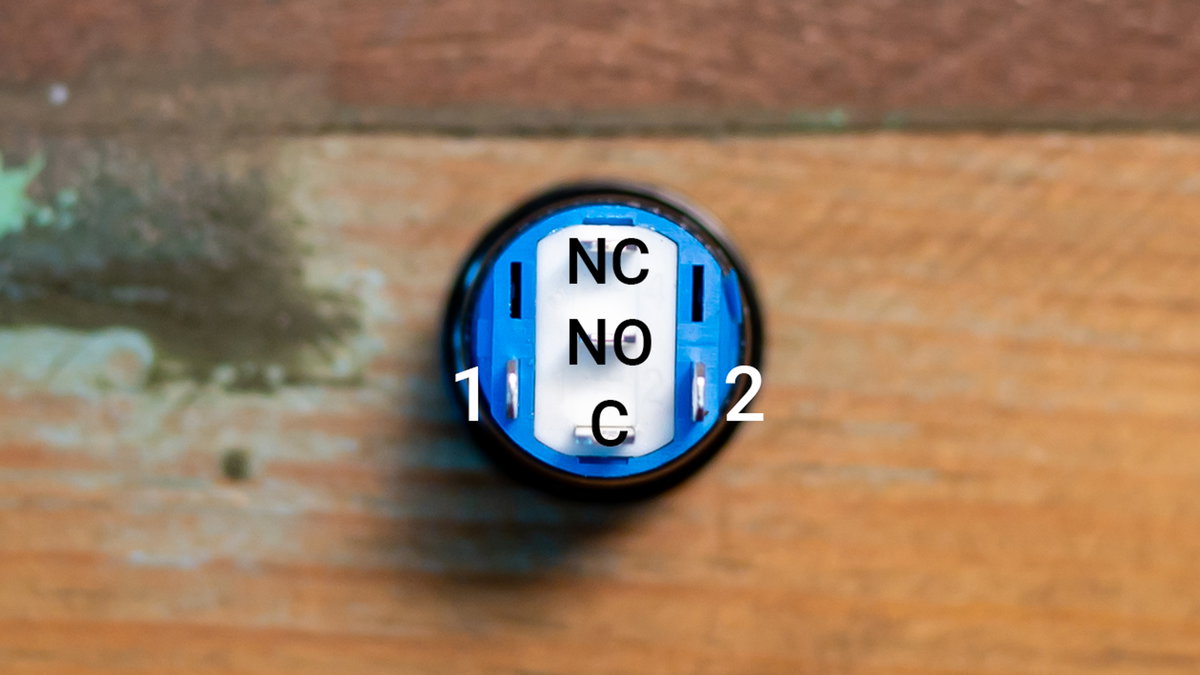Underside of the illuminated power button showing its five contacts