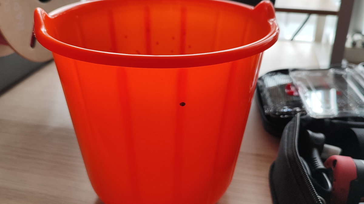 A black mark identifies where a drill will be inserted into a plastic bucket.